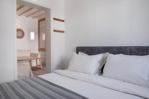 1 dormitorio con cama blanca y almohadas blancas en Casa Poco, 150 meters from Ornos Beach, en Ornos