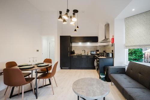 a living room and kitchen with a table and a couch at Parking, Wi-Fi, Sleeps 5, Self check-in, 2-bed apartment, long stays, Steppinghill, Contractors in Stockport