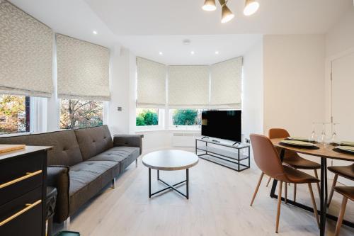 a living room with a couch and a table at Parking, Wi-Fi, Sleeps 5, Self check-in, 2-bed apartment, long stays, Steppinghill, Contractors in Stockport