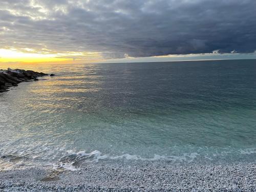 マリーナ・ディ・ピサにあるDomus Libeccio 57の岩場の海に沈む夕日