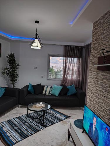 a living room with a couch and a tv at Résidence soltana Bizerte Vue sur mer in Dar el Koudia