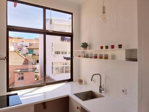 a kitchen with a sink and a window at Stylish Cacilhas rooms near the ferry to central Lisbon in Almada
