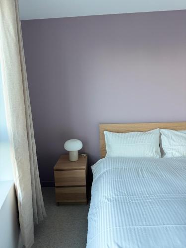 a bedroom with a white bed and a night stand at 02 Arena, Thames Riverside Retreat in London