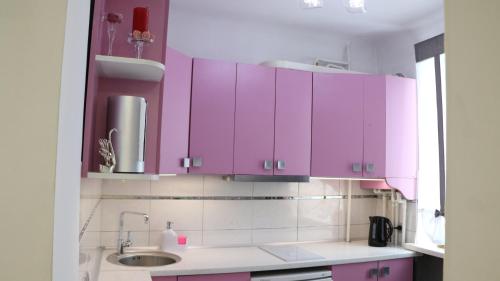 una cocina con armarios rosas y un fregadero en Heart of Chișinău, en Chişinău