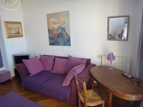 メール・レ・バンにあるBeau studio, front de mer - RDCの紫色のソファとテーブル付きのリビングルーム