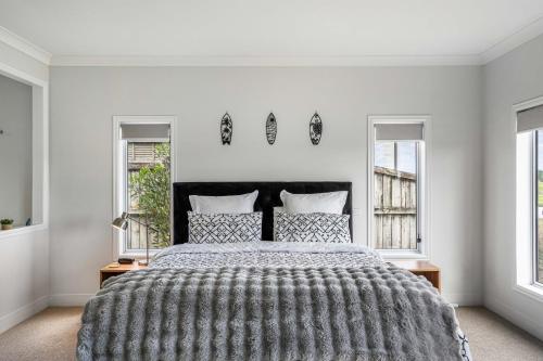 Un pat sau paturi într-o cameră la Sunlit Shores - Papamoa Holiday Homes