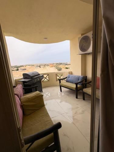 a living room with a couch and a view of the desert at Stella Heights in El Alamein