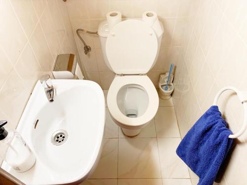 een badkamer met een wit toilet en een blauwe handdoek bij Waves Sound Surf House Completo in Santoña