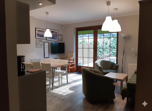 een woonkamer met een tafel en een eetkamer bij domy szeregowe Nasza Chata - 4 minuty od plaży in Pobierowo