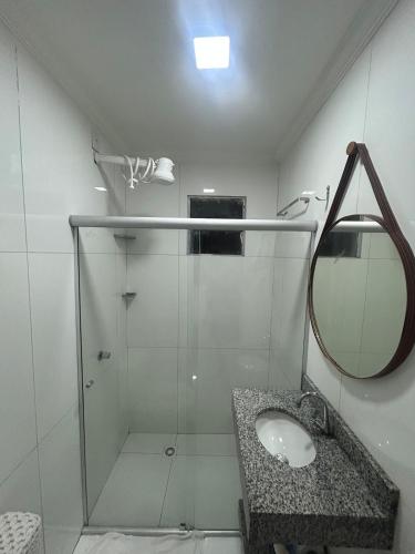 a bathroom with a shower and a sink and a mirror at Casa siles 2 in Mucugê