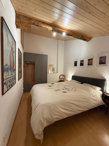 a bedroom with a large bed and a wooden ceiling at Renovated traditional chalet in car-free Mürren in Mürren