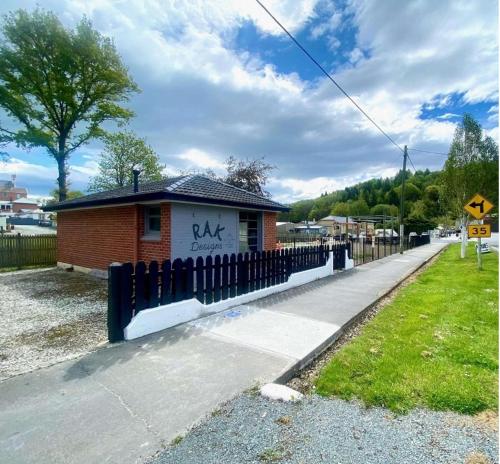a small building with graffiti on it next to a fence at The Batch in Lawrence