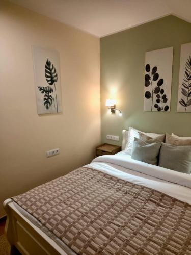 a bedroom with a bed and two paintings on the wall at Silent Retreat, Boutique Suite inside Monastery in Suceava