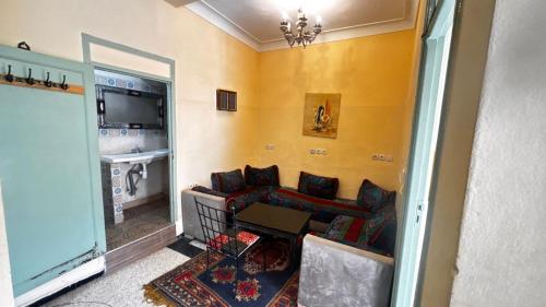 uma sala de estar com um sofá e uma mesa em Les appartements de la Koutoubia em Marraquexe