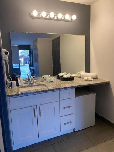 a bathroom counter with a sink and a mirror at Hotel 10 Extended Stay in New Orleans
