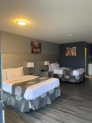 a hotel room with two beds and two lamps at Hotel 10 Extended Stay in New Orleans