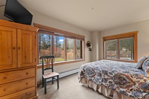 ein Schlafzimmer mit einem Bett, einer Kommode und einem TV in der Unterkunft Red Hawk Lodge 2204 in Keystone