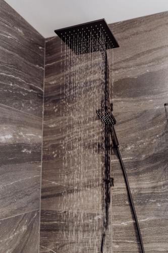 a shower with a shower head in a bathroom at Pods on Fraser in Bicheno