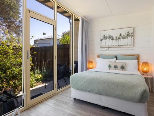 a bedroom with a bed and a sliding glass door at Peninsula Beach Motel in Rosebud