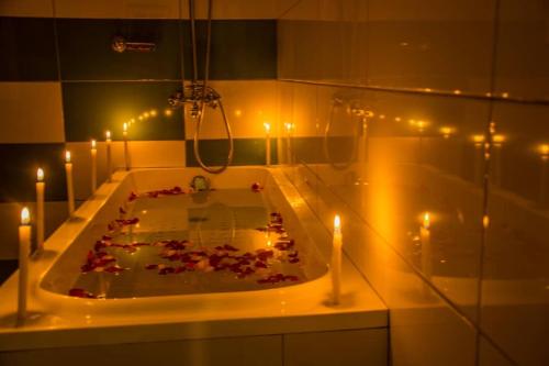 a bathroom with a bath tub with candles in it at Fortbella Tourist Inn in Njara