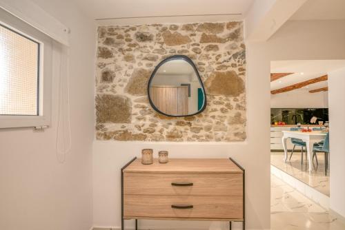 a mirror on a wall above a dresser in a room at Huzuri Retreat in Ayiós Nikólaos