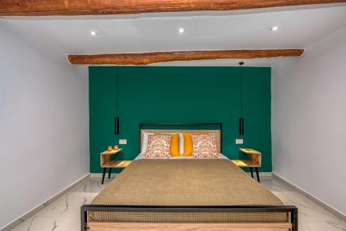 a bedroom with green walls and a bed with orange pillows at Huzuri Retreat in Ayiós Nikólaos