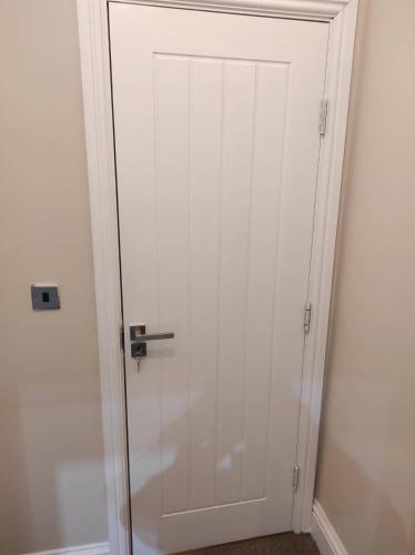 een witte deur met een metalen handvat in een kamer bij Relax Graza of Marsel in Cambridge