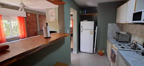 una cocina con encimera y refrigerador en El Encuentro, en Las Grutas