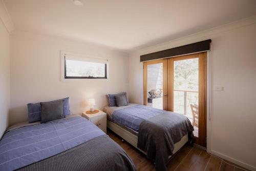 Surveyors BayにあるThe Beach Box at Big Roaring Beach Tasmaniaの窓のある部屋にベッドが2つある