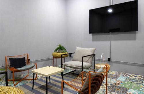 a room with chairs and a tv on a wall at Hostal CASA MX bellas artes in Mexico City