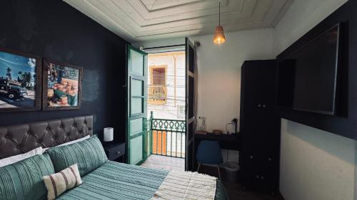 a bedroom with a bed and a view of a balcony at Casa Mosaiko Sonsón in Sonsón