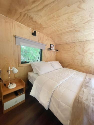 a bedroom with a large bed in a tiny house at Pucura Eco Lodge in Licán Ray