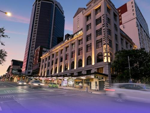 a building on a city street with cars at Attic Backpackers in Auckland