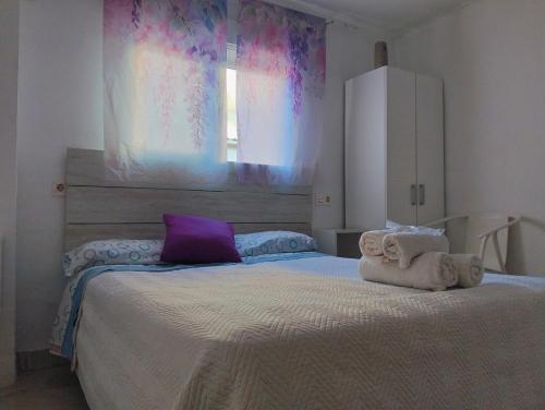 a bedroom with a large bed with towels on it at Alojamiento de habitaciones Zaidín in Granada