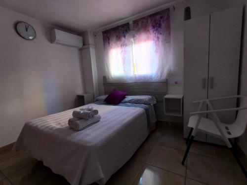 a small bedroom with two beds and a window at Alojamiento de habitaciones Zaidín in Granada