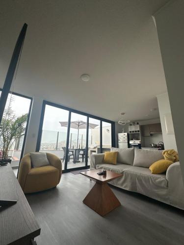 een woonkamer met een bank en een tafel bij Luxury Duplex on the 15th Floor with Terrace in Lima