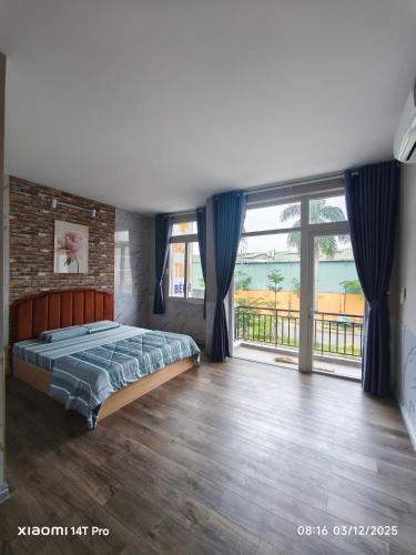 ein Schlafzimmer mit einem Bett und einem großen Fenster in der Unterkunft Biệt Thự 3 Phòng Ngủ A1-03 in Ðức Hòa
