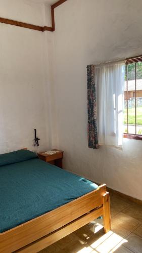 een slaapkamer met een bed en een raam bij Complejo Las Tonas in Las Toninas