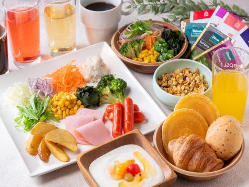 a table with plates of food and bowls of different foods at APA Hotel Sugamo Ekimae in Tokyo