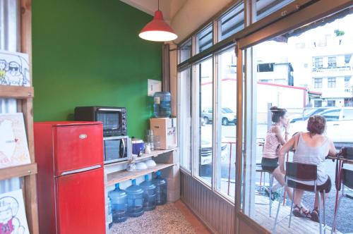 two women standing in a restaurant looking out the window at Hostel Who Knows in Taitung City