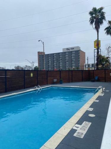 a large blue swimming pool with a building in the background at Hotel 10 Extended Stay in New Orleans