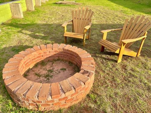 two chairs and a brick fire place in a yard at Casa La Vigie in Águas de Lindoia