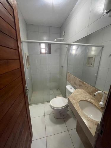 a bathroom with a shower and a toilet and a sink at Morada do vento in São Miguel do Gostoso