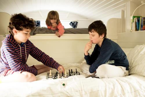 two young children playing chess in a bed at Burren Glamping in Kilfenora