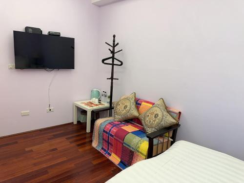 Una sala de estar con un sofá y un televisor en una pared. en Jiufen Golden House, en Jiufen