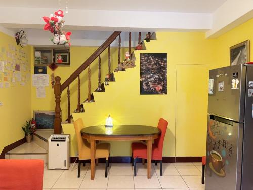 Un comedor con una mesa y una escalera. en Jiufen Golden House, en Jiufen