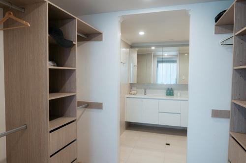 a bathroom with a walk in closet with a sink at Oceana - A Panoramic Beachfront Escape for Groups in Port Elliot