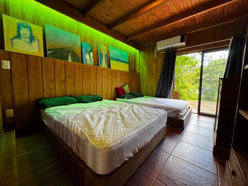 Dos camas en una habitación con paredes verdes. en Departamento con vista al lago, en Puerto Libertad