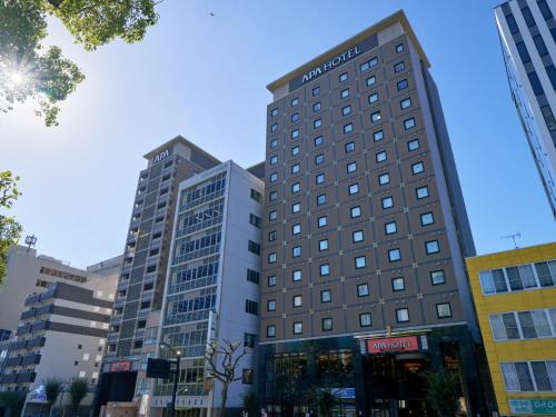 two tall buildings in a city at APA Hotel Hiroshima Ekimae Ohashi in Hiroshima