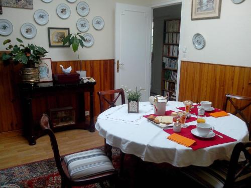 ein Esszimmer mit einem Tisch und einem weißen Tischtuch in der Unterkunft L'Orangine in Le Bouscat